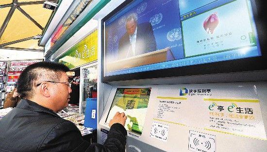 A citizen touches the screen installed in the new digital newsstand. [Photo: the Beijing Youth Daily]