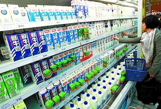 A consumer picks milk at a shelf in a supermarket. (Photo source: Chongqing Morning News)
