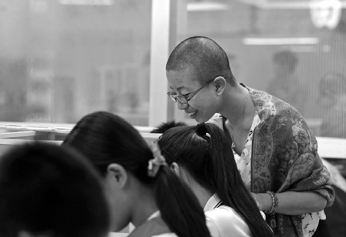 A female head teacher at a school in Wenzhou, Zhejiang province, shaved her head completely after losing a bet with teachers over whether they can help students improve their learning interests. (Photo source: 66wz.com)