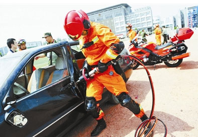 A rescuer dismantles the door of a car in a drill. (Photo/Beijing Youth Daily)