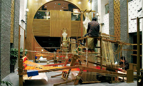 Weavers operate a dahualou loom at the Chengdu Shu Brocade and Embroidery Museum. The ancient loom is made entirely of wood, without a single nail. (Photos by Liu Yuanqi / For China Daily)