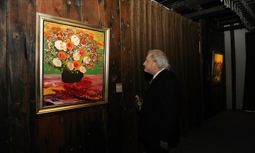 Marcestel takes in one of his paintings Photo: Lu Bing