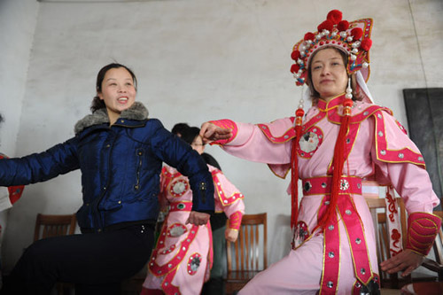 Dorota Jasik (right), a teacher from Poland working at Liaocheng University in Shandong Province, learns to play legendary female warrior Hua Mulan in Yuju Opera in Liaocheng in March. [Photo: Dong Guangqiang / China Daily]