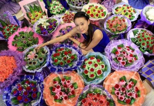 A woman buys flowers at a flower stand in Huangshan, East China's Anhui province, Aug 22, 2012. [Shi Guangdong/Asianewsphoto]