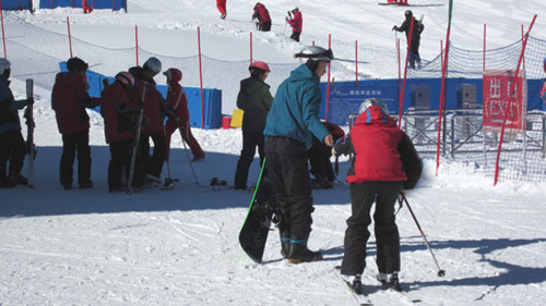 An instructor helps a novice skier at the Changbaishan Ski resort on February 17, 2013.[Photo by Lance Crayon/chinadaily.com.cn]