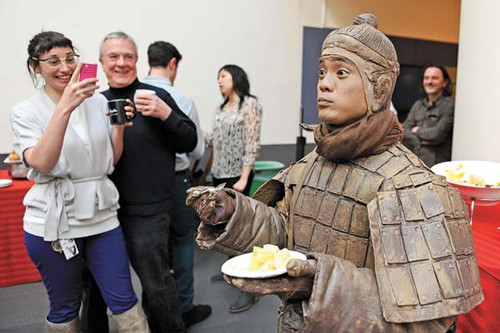 A man clad as a Terracotta Warrior draws visitors' attention to the first major US exhibition of relics of the Qin Dynasty (221-206 BC).[Photo by Chen Gang / China News Service]