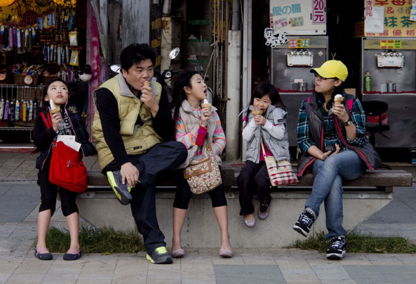 Family of five enjoys ice cream on a street in New Taipei City. [Photo by He Yanguang / for China Daily]  