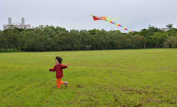 A girl flies a kite in a quiet park in Yilan. [Photo by Lu Beifeng / for China Daily]  