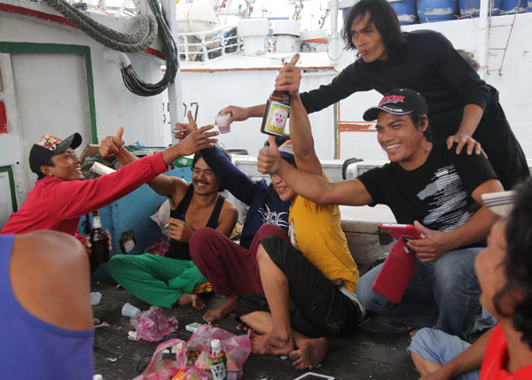 Fishermen enjoy their lunch on a boat in a fishing port in Keelung. [Photo by Huo Wei / for China Daily]  