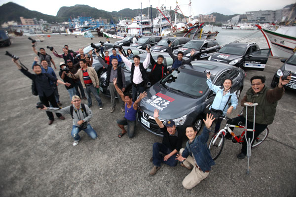 Professional photographers from the mainland pose for a group photo in Taiwan. [Photo by Pan Xiaoxuan / China Daily]  