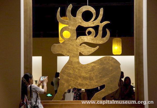 A woman takes a photo at the exhibition. [Photo/capitalmuseum.org.cn]