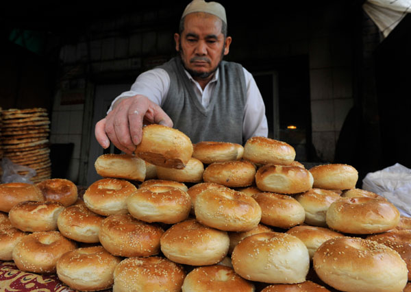 A vender at Erdaoqiao, Urumqi was putting freshly baked small oil nangs on display to attract customers. [Photo by Han Liang/For China Daily]