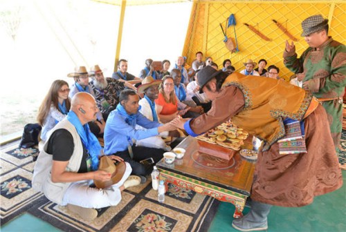 Guests exchange snuff bottle, a Mongolian tradition, with the 'groom' at a mock wedding organized for diplomats and visitors in the middle of a desert in Ordos, Inner Mongolia, June 27, 2015. Photo/chinadaily.com.cn