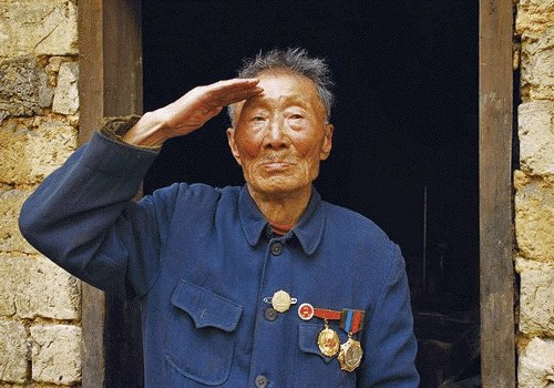 KMT veteran Wang Feihuan gave a salute in front of his sod house.