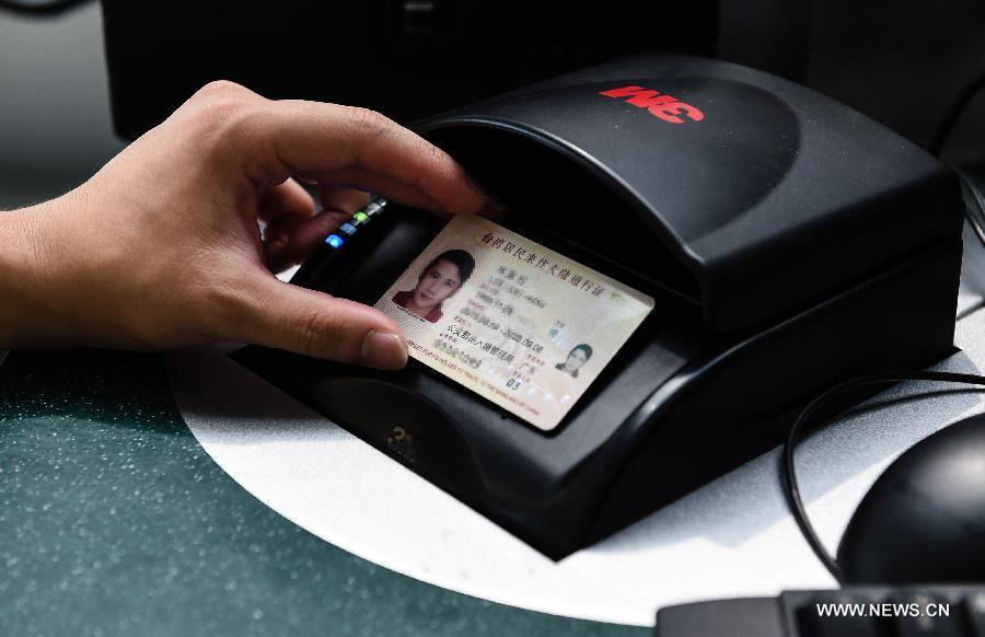 An immigration police officer checks a renewed Taibaozheng, a passport-like document that carries the entry permits for Taibao, or Taiwan compatriots, in Lukou Airport of Nanjing, capital of east China\'s Jiangsu Province, Sept. 21, 2015. The electronic version of Taibaozheng, which is in the form of a card instead of the former paper form, is enabled on the Chinese mainland on Monday. The electronic Taibaozheng, which also serves as the certificate of identity during Taiwan residents\' stay on the mainland, will bring more convenience for Taiwanese travelling between Taiwan and the mainland. (Photo: Xinhua/Li Xiang)