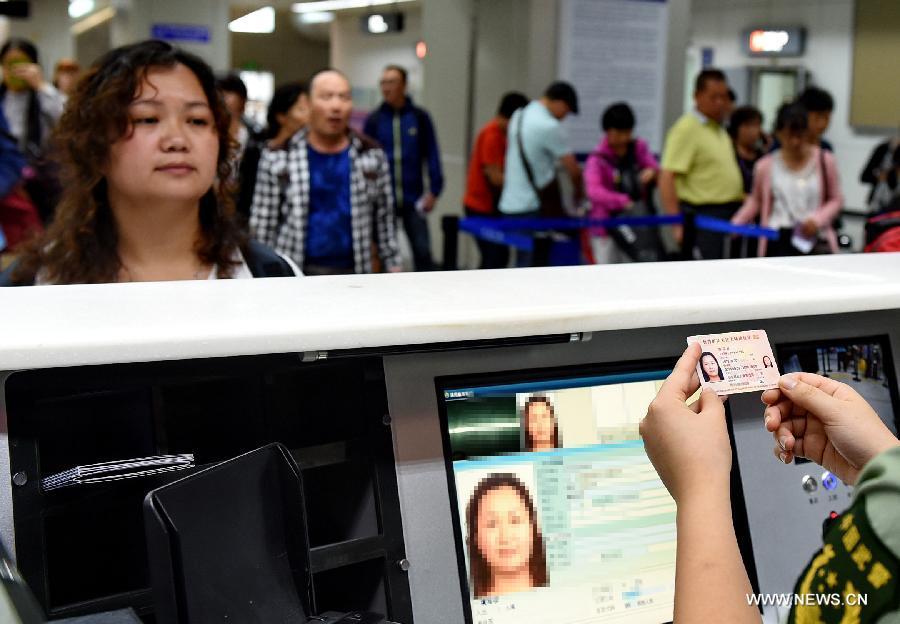 A police officer checks a woman\'s renewed Taibaozheng, a passport-like document that carries the entry permits for Taibao, or Taiwan compatriots, in Changle Airport of Fuzhou, capital of southeast China\'s Fujian Province, Sept. 21, 2015. The electronic version of Taibaozheng, which is in the form of a card instead of the former paper form, is enabled on the Chinese mainland on Monday. The electronic Taibaozheng, which also serves as the certificate of identity during Taiwan residents\' stay on the mainland, will bring more convenience for Taiwanese travelling between Taiwan and the mainland. (Photo: Xinhua/Zhang Guojun)