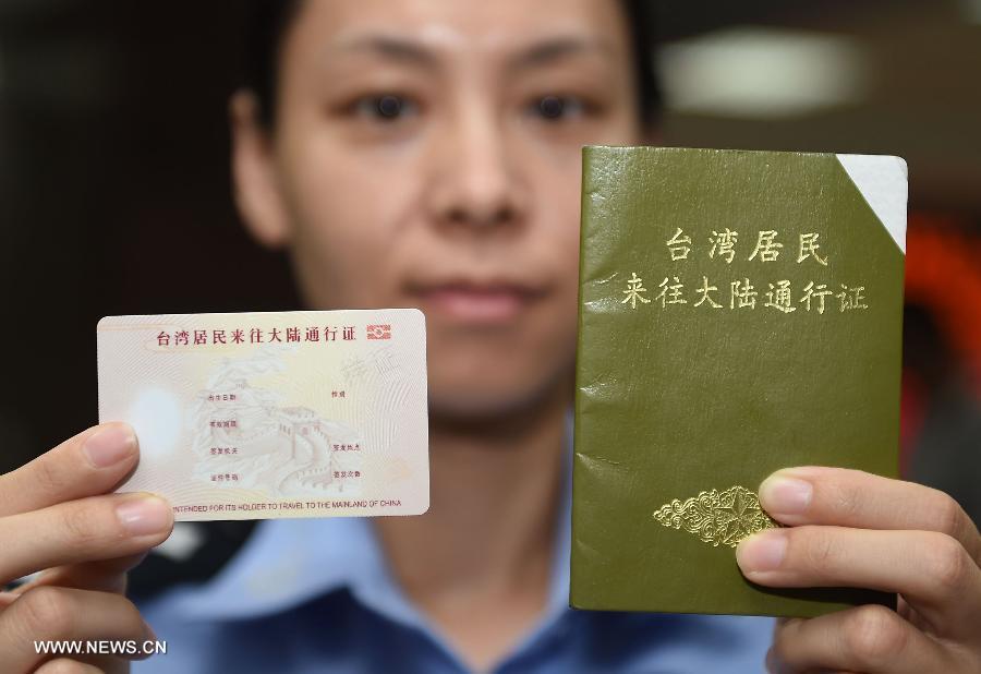 A police officer shows the renewed Taibaozheng (L), a passport-like document that carries the entry permits for Taibao, or Taiwan compatriots, and the former paper version of Taibaozheng in Beijing, capital of China, Sept. 21, 2015. The electronic version of Taibaozheng, which is in the form of a card instead of the former paper form, is enabled on the Chinese mainland on Monday. The electronic Taibaozheng, which also serves as the certificate of identity during Taiwan residents\' stay on the mainland, will bring more convenience for Taiwanese travelling between Taiwan and the mainland. (Photo: Xinhua/Chen Yehua)