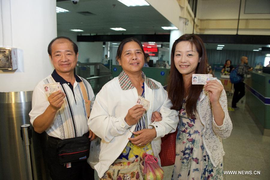 A family from Hsin-Chu of Taiwan shows their renewed Taibaozheng, a passport-like document that carries the entry permits for Taibao, or Taiwan compatriots, in Xiamen, southeast China\'s Fujian Province, Sept. 21, 2015. The electronic version of Taibaozheng, which is in the form of a card instead of the former paper form, is enabled on the Chinese mainland on Monday. The electronic Taibaozheng, which also serves as the certificate of identity during Taiwan residents\' stay on the mainland, will bring more convenience for Taiwanese travelling between Taiwan and the mainland. (Photo: Xinhua/Jiang Kehong)