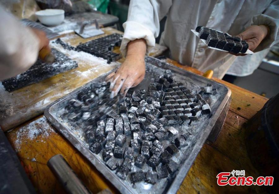 The black sesame seed filling is cut into small pieces. (Photo: China News Service/Liu Xin)