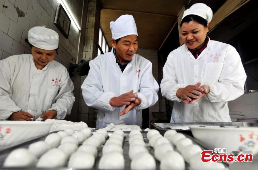 Cooks make Tangyuan with black sesame seed as a stuffing. (Photo: China News Service/Zhang Chang)