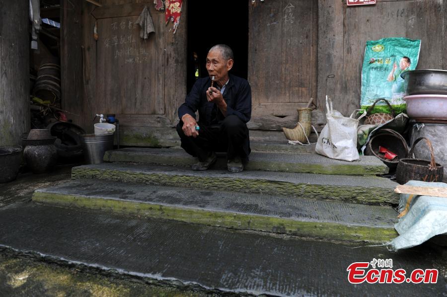 A man of the Dong ethnic group smokes in Zaidang Dong Village, Rongjiang County, Southwest China’s Guizhou Province, May 31, 2016. The village of Dong people has well-preserved architecture built during the Qing Dynasty (1644-1911), including a 12-meter-high bdrum uilding. The village is also known for the ethnic group’s unique folk chorus. (Photo: China News Service/He Junyi)