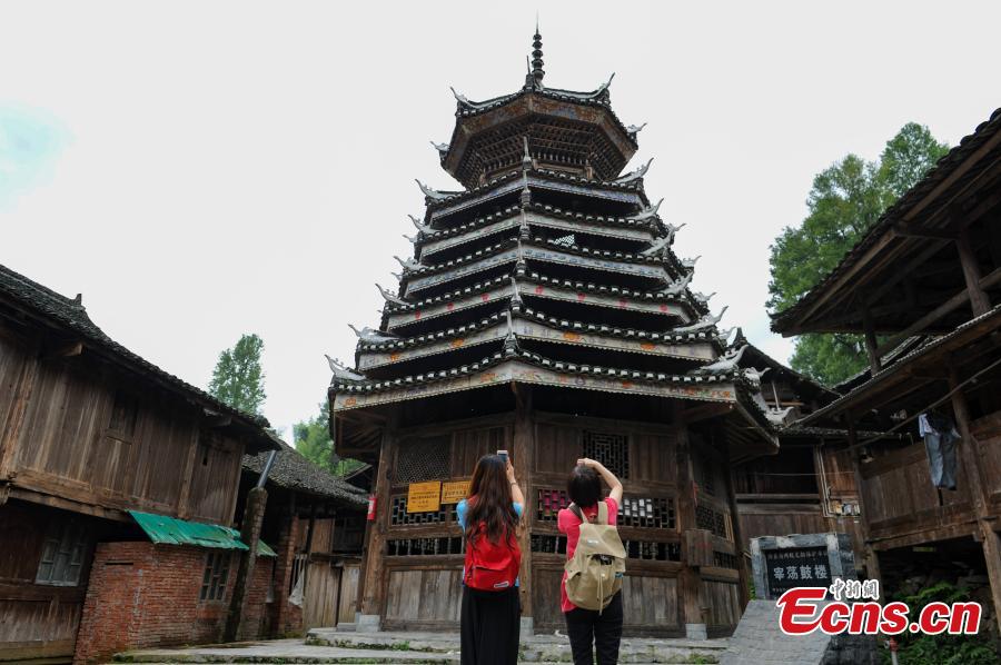 Two visitors take photos of a drum building in Zaidang Dong Village, Rongjiang County, Southwest China’s Guizhou Province, May 31, 2016. (Photo: China News Service/He Junyi)