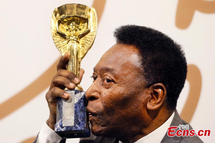 Brazilian former footballer Pele kisses his copy of the Jules Rimet Trophy, during a media opportunity in London, June 1, 2016. The three-time World Cup Champion, FIFA Player of the Century and Brazilian Football icon, will offer 2,000 items of his football memorabilia, including the replica Jules Rimet trophy, to be auctioned on June 7, 8 and 9 in London. (Photo/Agencies)