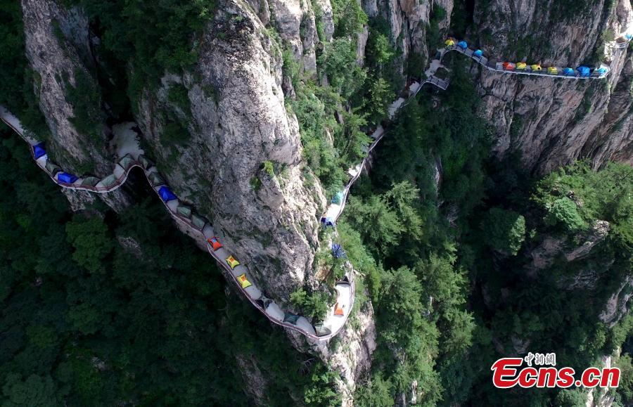 A line of tents on a suspended pathway built on the cliff, about 1,000 meters above the ground, at Laojun Mountain in Luoyang City, Central China’s Henan Province, July 16, 2016. The mountain is known for its cultural heritage relating to Taoism as it was once the retreat of Laozi, a great Chinese philosopher and the founder of Taoism. The mountain is hosting a tenting festival, which has attracted hundreds of tourists. (Photo: China News Service/Wang Zhongju)