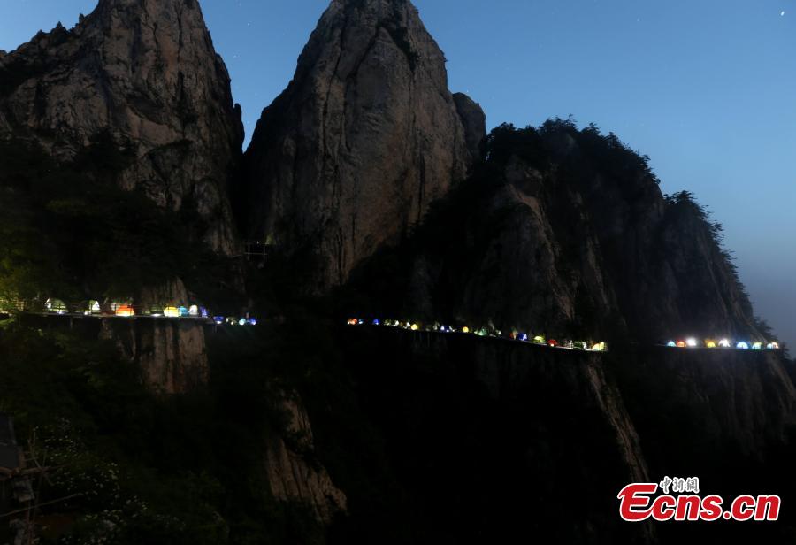 A line of tents on a suspended pathway built on the cliff, about 1,000 meters above the ground, at Laojun Mountain in Luoyang City, Central China’s Henan Province, July 16, 2016. The mountain is known for its cultural heritage relating to Taoism as it was once the retreat of Laozi, a great Chinese philosopher and the founder of Taoism. The mountain is hosting a tenting festival, which has attracted hundreds of tourists. (Photo: China News Service/Wang Zhongju)