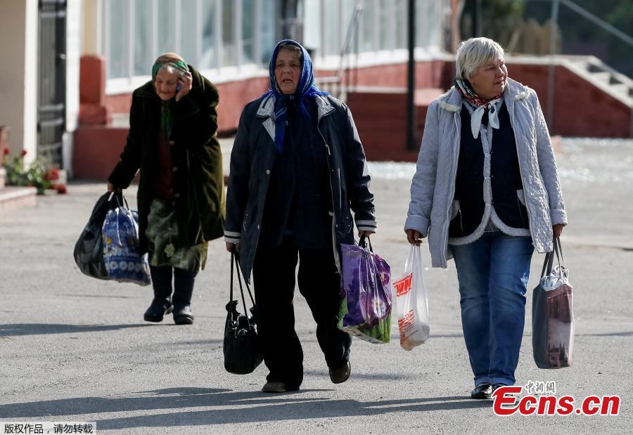 Local residents walk to the evacuation bus, near the warehouse storing ammunition for multiple rocket launcher systems at a military base in Kalynivka, Vinnytsia region, Ukraine September 27, 2017. (Photo/Agencies)