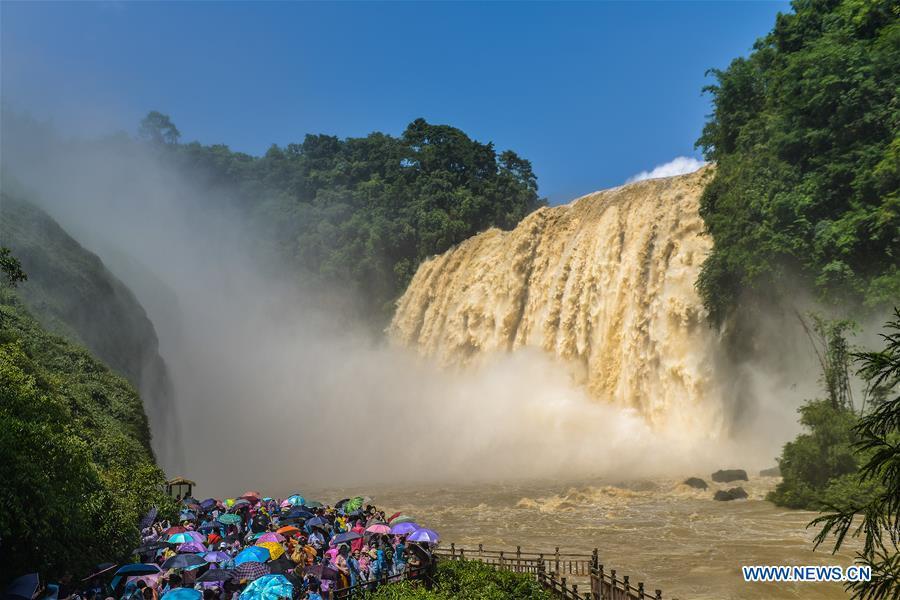 Tourists visit the Huangguoshu Waterfall in Anshun, southwest China\'s Guizhou Province, on June 20, 2018. Affected by sustained rainfall, the Huangguoshu Waterfall on Wednesday saw its maximum flow in this year\'s flood season, with the flow rate reaching 395 cubic meters per second. (Xinhua/Cui Yu)