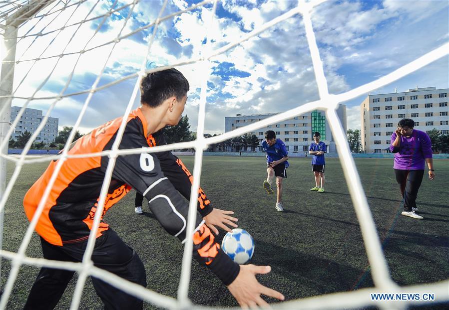 Sun Dongyuan (2nd L) and his teammates have a training at the special education school of Changchun University in northeast China\'s Jilin Province, June 20, 2018. Sun Dongyuan and Fan Changjie, who were diagnosed with congenital eye disease, learn acupuncture and massage in the school. They are also players of the school\'s football team for visually impaired students. During the match, Sun and Fan identify position via a bell inside the ball and with guides\' instructions. The FIFA World Cup 2018 has become their popular topic since June 14, and they listen to the live broadcast and cheer for their favorite teams. (Xinhua/Xu Chang)