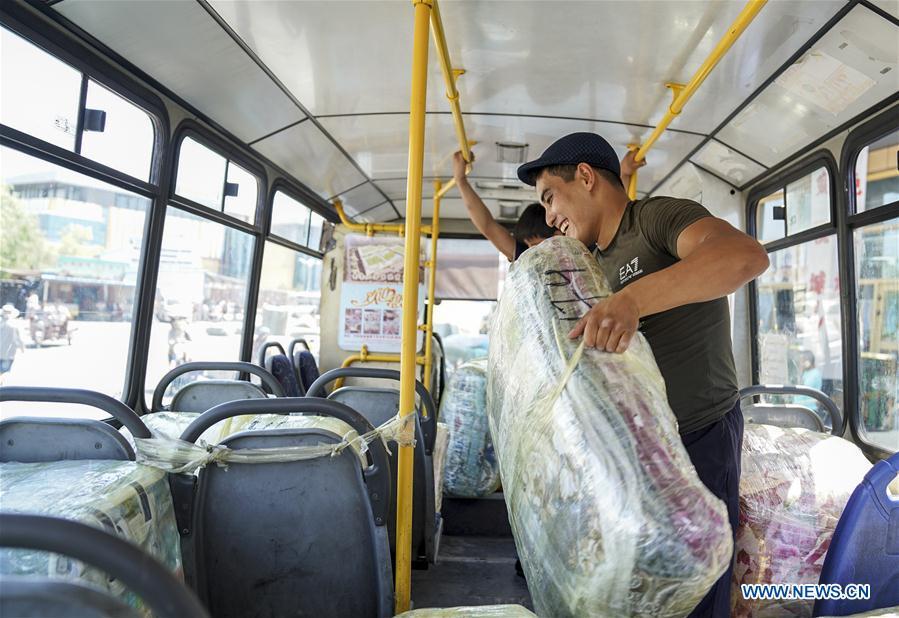 A trader from Kazakhstan carries cargo in Horgos, northwest China\'s Xinjiang Uygur Autonomous Region, Aug. 4, 2018. The trade at the China-Kazakhstan Horgos International Border Cooperation Center enters a busy season since the beginning of the summer tourism peak. (Xinhua/Li Mengjiao)