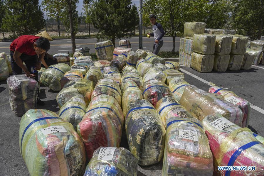 Traders from Kazakhstan pack cargo at the China-Kazakhstan Horgos International Border Cooperation Center in Horgos, northwest China\'s Xinjiang Uygur Autonomous Region, Aug. 4, 2018. The trade at the China-Kazakhstan Horgos International Border Cooperation Center enters a busy season since the beginning of the summer tourism peak. (Xinhua/Hu Huhu)