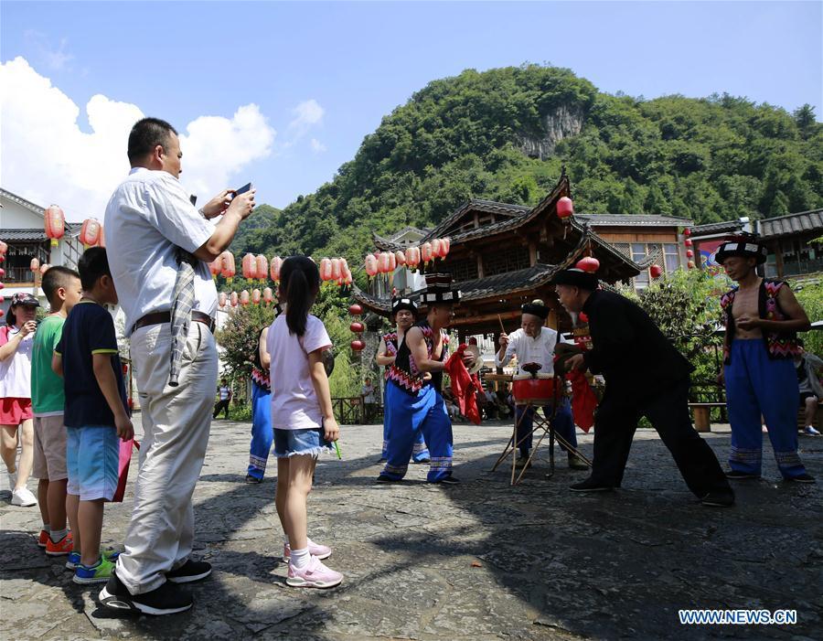 Jin De\'an (3rd R) and his team perform Daliuzi for tourists at Xibu Street, a scenic spot in the Wulingyuan District of Zhangjiajie City, central China\'s Hunan Province, Aug. 7, 2018. Daliuzi is a kind of local musical instrument performance with a long history. Jin De\'an is the creator of \