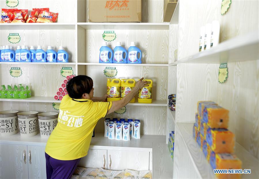 A staff member arranges commodities exchangeable in a supermarket for points earned through garbage classification in Lipu Township of Zhuji City, east China\'s Zhejiang Province, Aug. 9, 2018. Local government has rolled out a mechanism to encourage people to do garbage sorting, in which residents can redeem commodities with points earned from garbage classification or by answering questions about garbage classification. (Xinhua/Han Chuanhao)