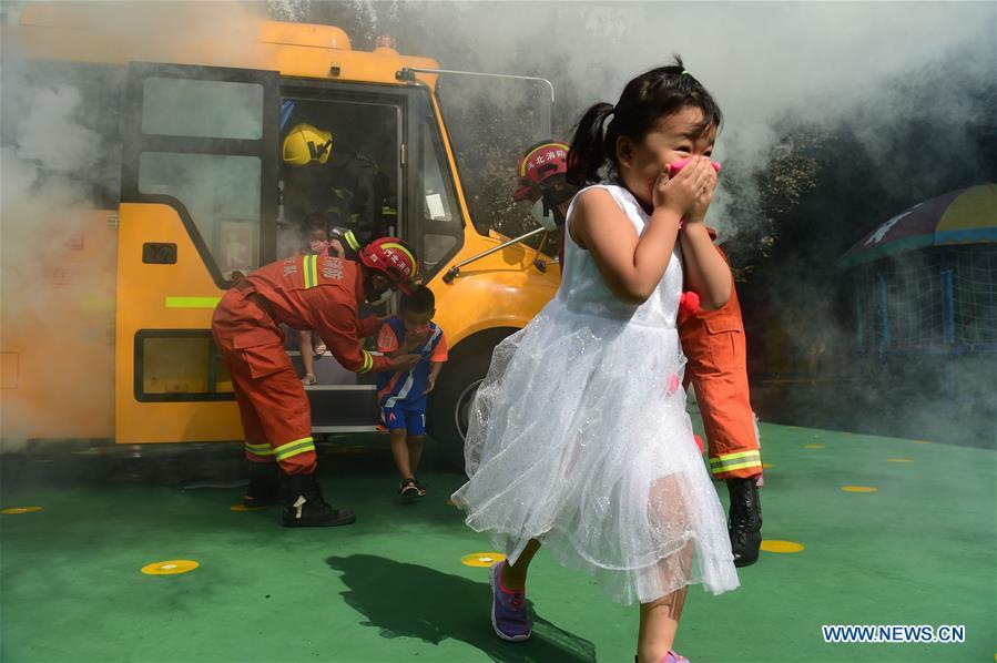 Children take part in a fire drill at Xinhua District of Cangzhou City, north China\'s Hebei Province, Aug. 27, 2018. Children and students at Xinhua District participated in a drill of fire emergency before the new semester. (Xinhua/Fu Xinchun)