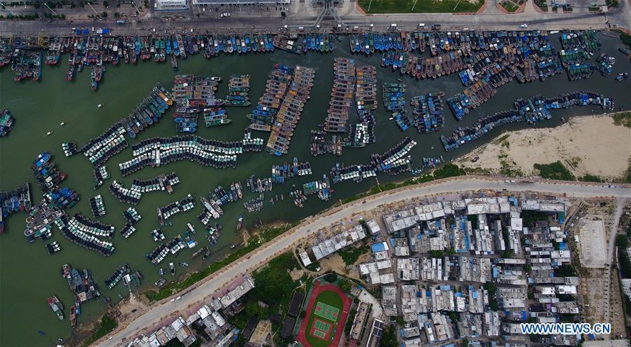 Aerial photo taken on Sept. 14, 2018 shows fishing boats returning to harbor at a fishing port in Sanya, south China\'s Hainan Province. Mangkhut, the 22nd typhoon this year, is expected to land in south China\'s Guangdong and Hainan provinces on the night of Sept. 16. (Xinhua/Yang Guanyu)