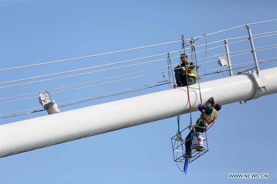 Staff members carry out cleaning and maintenance work on one of the main cables of the Sidu River Bridge in central China\'s Hubei Province, Oct. 10, 2018. The suspension bridge crosses the Sidu River valley near the boundaries of Yichang and Enshi in Hubei Province. The top point of the bridge is 650 meters above the bottom of the valley, a height comparable to a 200-storey skyscraper. (Xinhua/Zhu Wei)