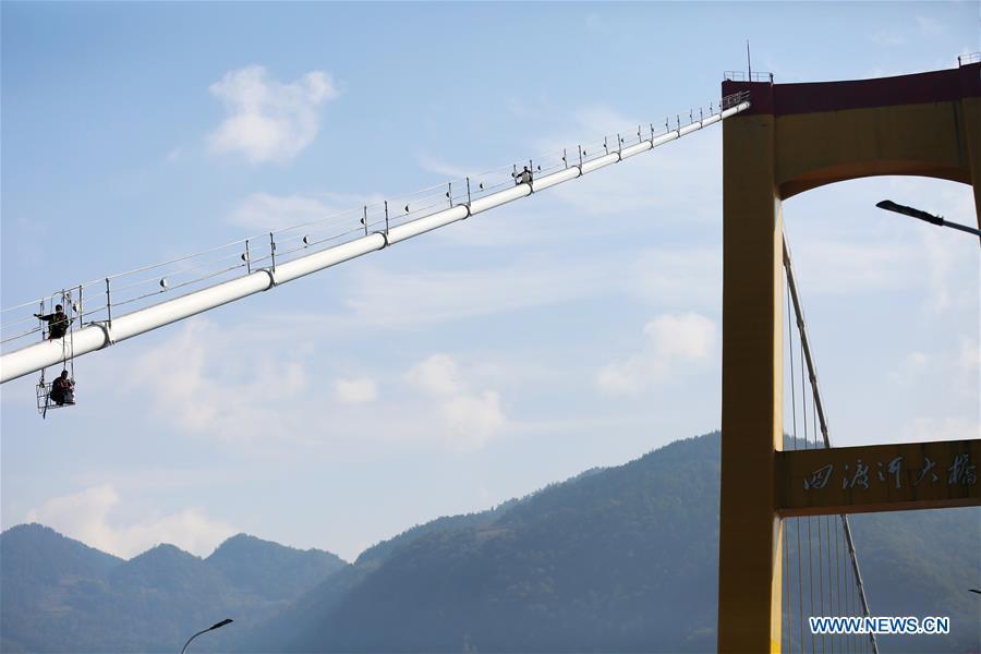 Staff members carry out cleaning and maintenance work on one of the main cables of the Sidu River Bridge in central China\'s Hubei Province, Oct. 10, 2018. The suspension bridge crosses the Sidu River valley near the boundaries of Yichang and Enshi in Hubei Province. The top point of the bridge is 650 meters above the bottom of the valley, a height comparable to a 200-storey skyscraper. (Xinhua/Zhu Wei)