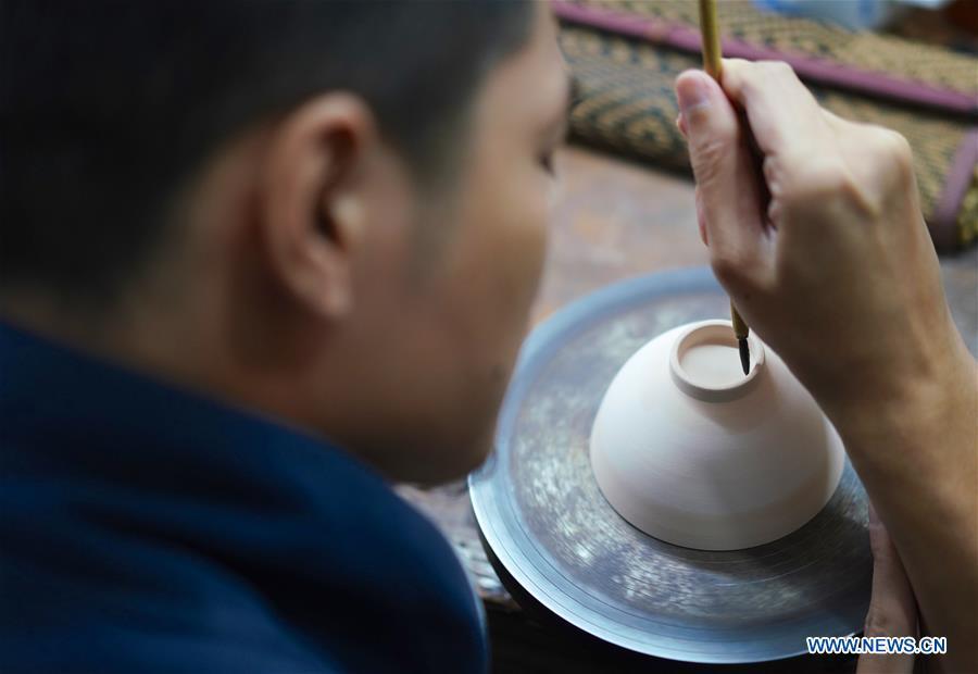 A craftsman named Peng Yongliang edges the bottom of an eggshell porcelain body in Jingdezhen, east China\'s Jiangxi Province, on Oct. 19, 2018. Eggshell porcelain, one of the traditional porcelains produced in \