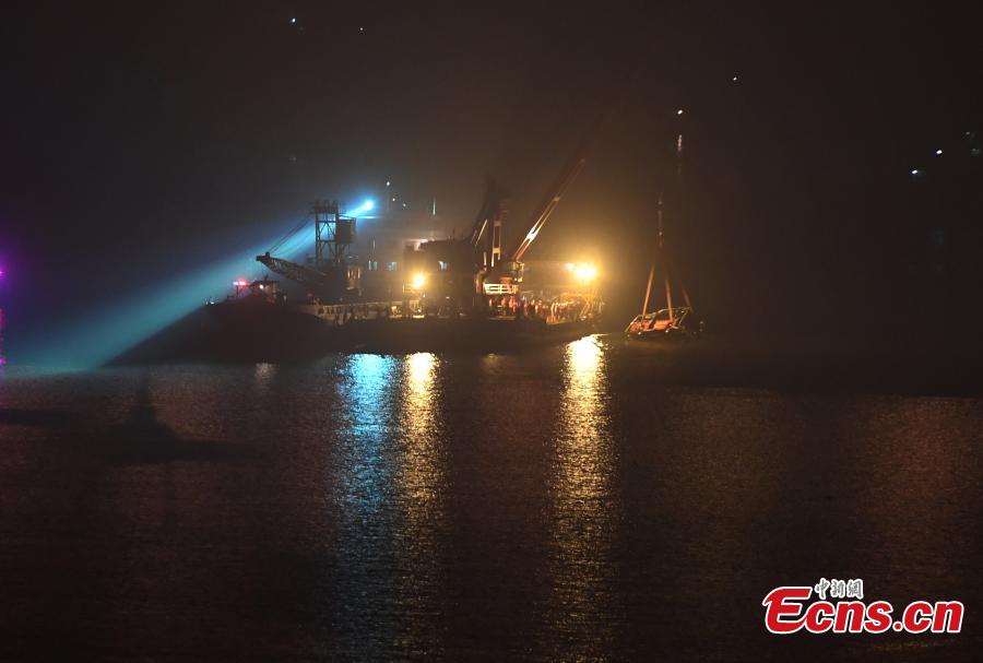 Rescuers on Wednesday night salvaged the wreck of a bus that plunged into the Yangtze River in Chongqing Municipality leaving at least nine people dead. The bus was pulled out of water by a floating crane at about 11:30 p.m.. Rescuers are expected to enter the bus to search for bodies of victims. The bus veered onto the wrong side of the road and collided into an oncoming car before breaking through road fencing and falling off a bridge in Chongqing\'s Wanzhou District on Sunday.(Photo: China News Service/ Chen Chao)