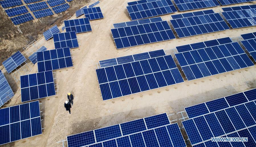In this aerial photo taken on Nov. 7, 2018, workers patrol a photovoltaic power station built under an inter-village poverty relief program in Huojiaping Village of Yihe Township, Suide County, northwest China\'s Shaanxi Province, Nov. 7, 2018. Located on the Loess Plateau, Suide County has abundant sunshine and idle lands which are ideal for the construction of photovoltaic power stations. Currently, local authorities are working with a provincial branch of electricity service provider State Grid on a 33-megawatt photovoltaic power station. (Xinhua/Liu Xiao)
