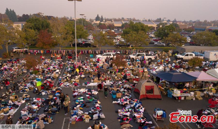 Fire evacuees sift through a surplus of donated items in a parking lot in Chico, California on November 17, 2018. More than 1,000 people remain listed as missing in the worst-ever wildfire to hit the US state.  (Photo/Agencies)