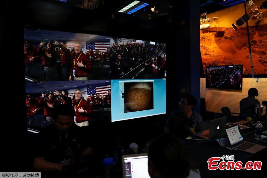 The mission control team at NASA\'s Jet Propulsion Laboratory (JPL) react on a video screen as the spaceship Insight, NASA\'s first robotic lander dedicated to studying the deep interior of Mars, sends its first picture back to JPL, in Pasadena, California, U.S. November 26, 2018.(Photo/Agencies)