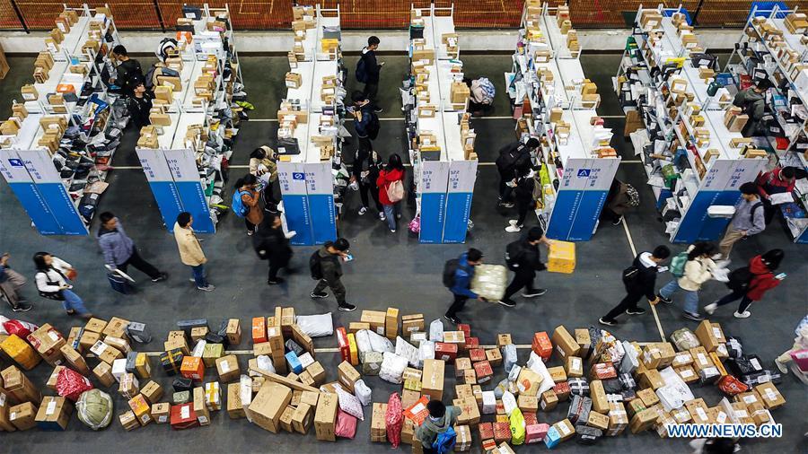 Faculty staff and students get their parcels at a makeshift collecting point in an indoor tennis court at Nanjing University of Aeronautics and Astronautics in Nanjing, capital of east China\'s Jiangsu Province, Nov. 13, 2018. China\'s express delivery sector handled 50.5 billion parcels in 2018, up 25.8 percent year on year, data from the State Post Bureau (SPB) showed. Gross business revenue of the sector increased 21.2 percent year on year to hit 601 billion yuan (about 88 billion U.S. dollars) last year, according to the SPB. (Xinhua/Li Bo)