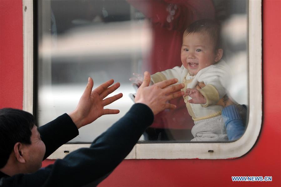 File photo taken on Jan. 26, 2013 shows a man making a hugging gesture to his grandson from outside the train window at the railway station in Hangzhou, east China\'s Zhejiang Province. Platforms, witnessing memorable moments of joy and sadness, are the epitome of each year\'s Spring Festival travel rush, during which hundreds of millions of Chinese go back to their hometowns for family gatherings. (Xinhua/Ju Huanzong)