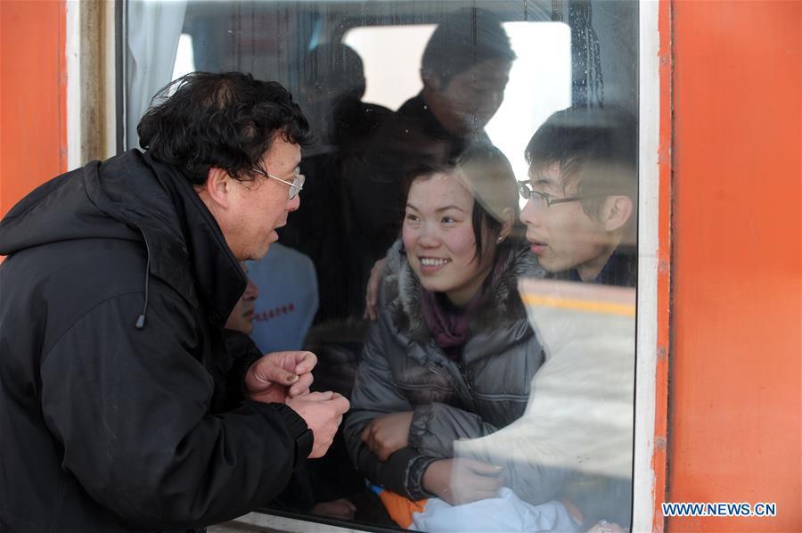 File photo taken on Feb. 19, 2010 shows Chen Zhongchen (1st L), in his sixties, saying goodbye to his son and daughter-in-law who are aboard a departing train towards Shanghai at the train station in Bozhou, east China\'s Anhui Province. Platforms, witnessing memorable moments of joy and sadness, are the epitome of each year\'s Spring Festival travel rush, during which hundreds of millions of Chinese go back to their hometowns for family gatherings. (Xinhua/Zhang Yanlin)