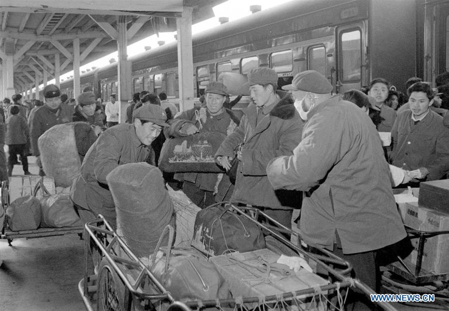 File photo taken during the Spring Festival travel rush in 1983 shows railway staff members carrying luggage for passengers with carts at Shanghai Railway Station in Shanghai, east China. Platforms, witnessing memorable moments of joy and sadness, are the epitome of each year\'s Spring Festival travel rush, during which hundreds of millions of Chinese go back to their hometowns for family gatherings. (Xinhua/Zhang Liuren)