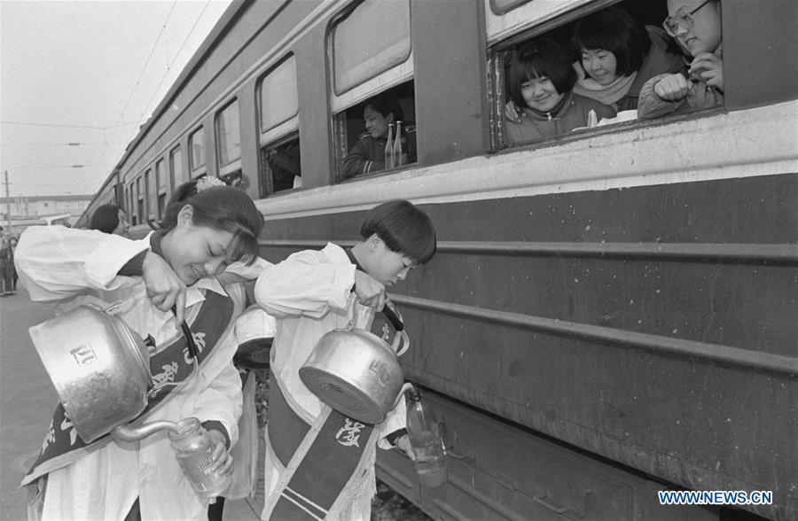 File photo taken during the Spring Festival travel rush in 1994 shows volunteers pouring hot water for passengers at Xi\'an Railway Station in Xi\'an, northwest China\'s Shaanxi Province. Platforms, witnessing memorable moments of joy and sadness, are the epitome of each year\'s Spring Festival travel rush, during which hundreds of millions of Chinese go back to their hometowns for family gatherings. (Xinhua/Tao Ming)